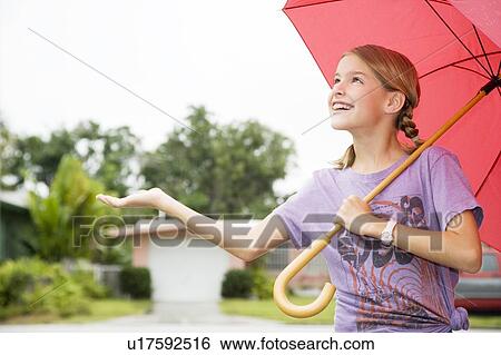 A young girl with an umbrella View Large Photo Image Stock Photograph - A young girl with an umbrella. Fotosearch