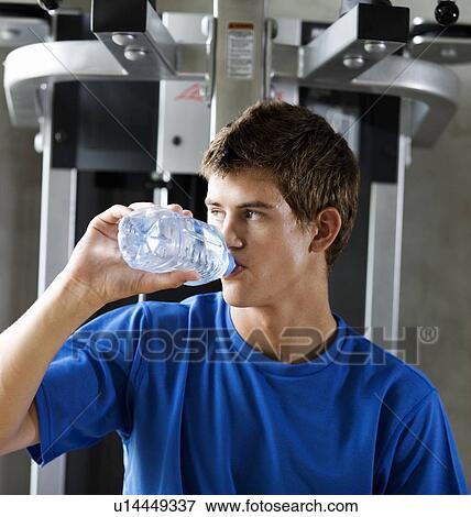 A young man drinking a bottle of water View Large Photo Image Stock Photo - A young man drinking a bottle of water. Fotosearch