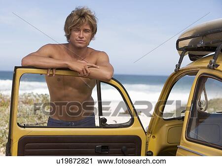 A young man leaning on the door of a car View Large Photo Image Stock Image - A young man leaning on the door of a car. Fotosearch