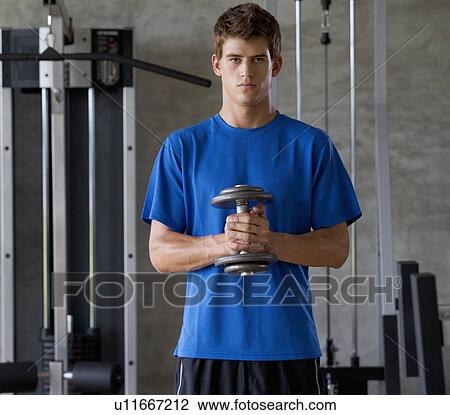 A young man lifting weights View Large Photo Image Stock Image - A young man lifting weights. Fotosearch