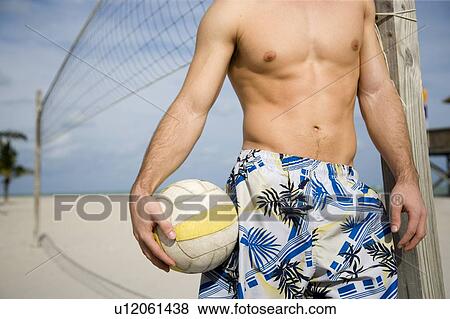 A young man playing beach volleyball View Large Photo Image Stock Photo - A young man playing beach volleyball. Fotosearch
