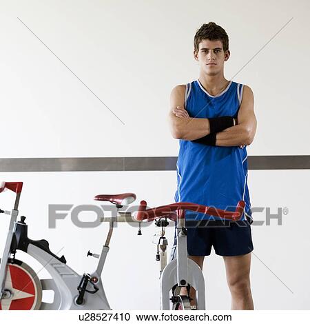 Stock Image - A young man standing in a gym. Fotosearch