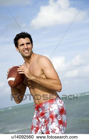 A young man with a ball on the beach View Large Photo Image Stock Image - A young man with a ball on the beach. Fotosearch