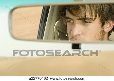 A young man's reflection in a rear view mirror View Large Photo Image Stock Image - A young man's reflection in a rear view mirror. Fotosearch
