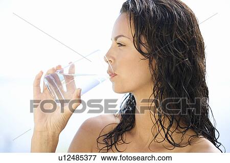 A young woman drinking a glass of water View Large Photo Image Stock Photo - A young woman drinking a glass of water. Fotosearch