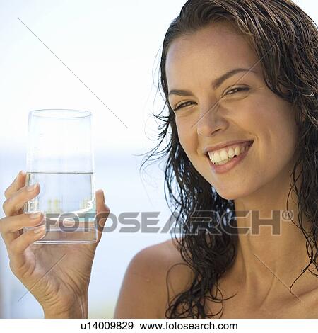 A young woman drinking a glass of water View Large Photo Image Stock Photo - A young woman drinking a glass of water. Fotosearch