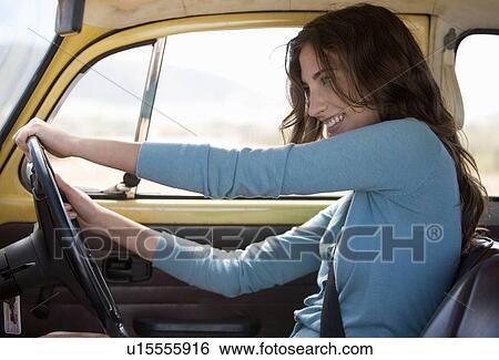 A young woman driving a car View Large Photo Image Stock Photograph - A young woman driving a car. Fotosearch