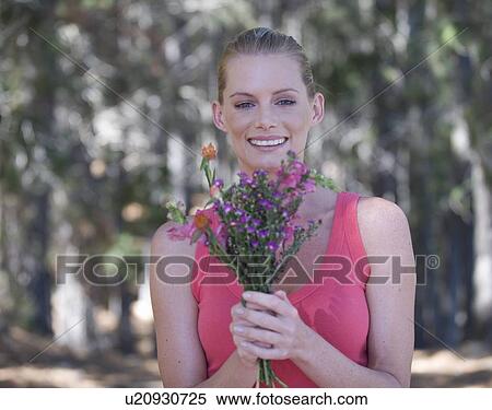 Stock Photography - A young woman holding a bouquet of flowers. Fotosearch