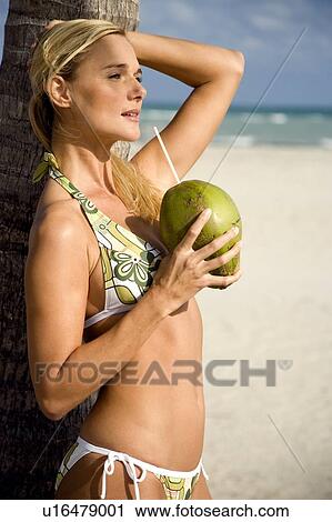 A young woman in a bikini standing on a beach View Large Photo Image Stock Image - A young woman in a bikini standing on a beach. Fotosearch
