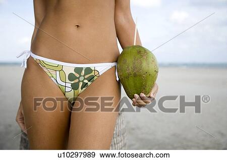 A young woman in a bikini standing on a beach View Large Photo Image Stock Photo - A young woman in a bikini standing on a beach. Fotosearch