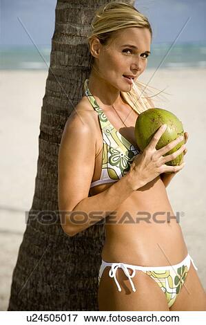 A young woman in a bikini standing on a beach View Large Photo Image Stock Photo - A young woman in a bikini standing on a beach. Fotosearch