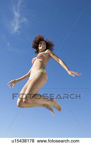 Stock Photo - A young woman jumping. Fotosearch