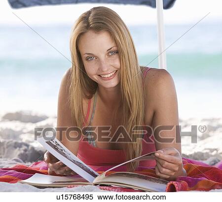 A young woman laying on a beach View Large Photo Image Stock Photography - A young woman laying on a beach. Fotosearch