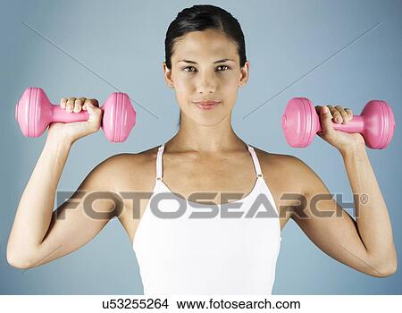 A young woman lifting weights View Large Photo Image Picture - A young woman lifting weights. Fotosearch