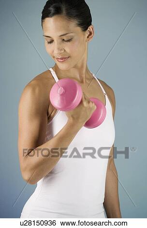 A young woman lifting weights View Large Photo Image Stock Photograph - A young woman lifting weights. Fotosearch