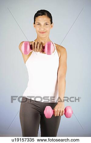 Stock Photography - A young woman lifting weights. Fotosearch