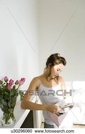 A young woman looking at old photographs View Large Photo Image Stock Image - A young woman looking at old photographs. Fotosearch