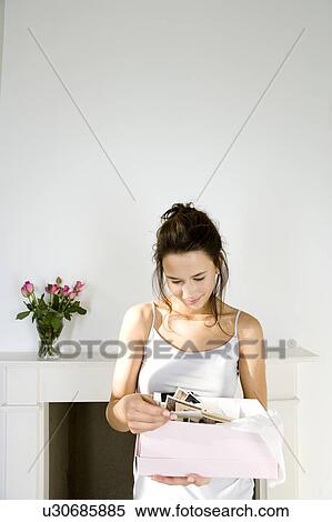 A young woman looking at old photographs View Large Photo Image Stock Photography - A young woman looking at old photographs. Fotosearch