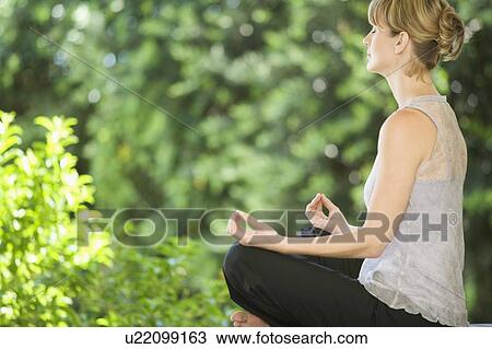 Stock Image - A young woman meditating. Fotosearch