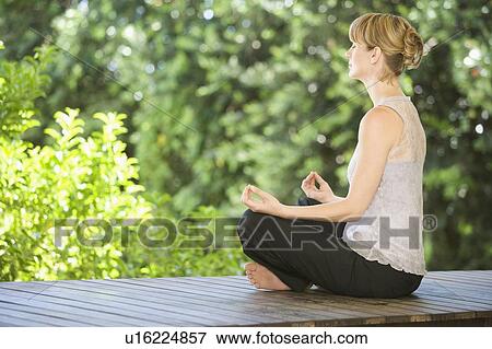 Stock Photo - A young woman meditating. Fotosearch