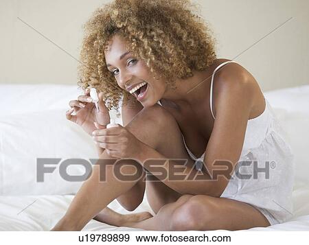 Stock Photo - A young woman painting her nails. Fotosearch