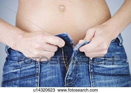 A young woman putting on jeans View Large Photo Image Stock Image - A young woman putting on jeans. Fotosearch