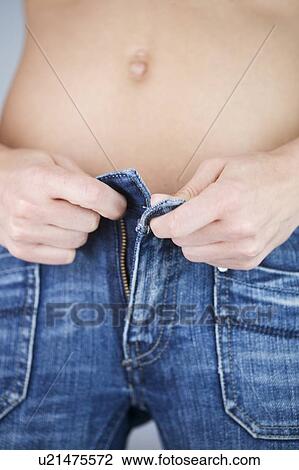 Stock Image - A young woman putting on jeans. Fotosearch