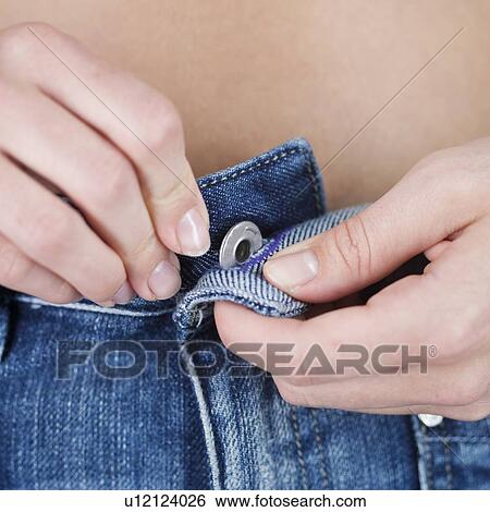A young woman putting on jeans View Large Photo Image Stock Photograph - A young woman putting on jeans. Fotosearch
