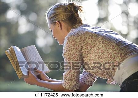 A young woman reading a book View Large Photo Image Stock Photography - A young woman reading a book. Fotosearch
