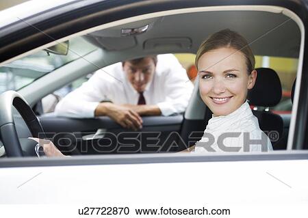 A young woman sitting in a new car View Large Photo Image Stock Image - A young woman sitting in a new car. Fotosearch