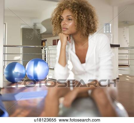 Stock Photography - A young woman sitting on an exercise ball. Fotosearch