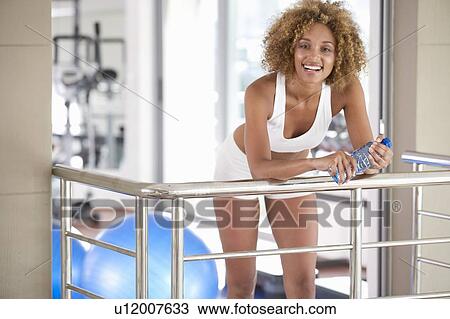 Stock Image - A young woman standing in a gym. Fotosearch