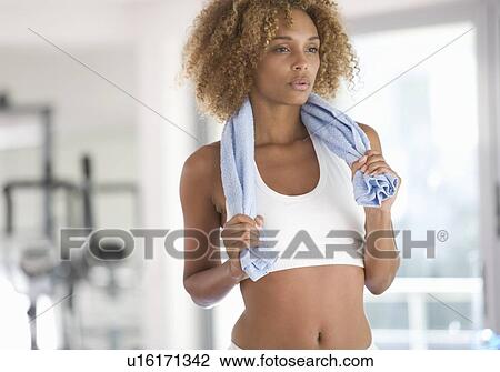 Stock Image - A young woman standing in a gym. Fotosearch