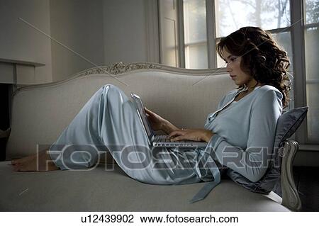 Stock Image - A young woman using a laptop. Fotosearch