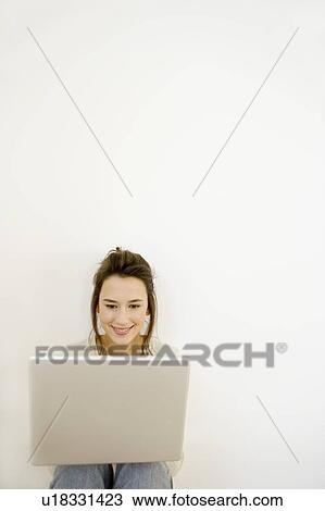 A young woman using a laptop View Large Photo Image Stock Image - A young woman using a laptop. Fotosearch