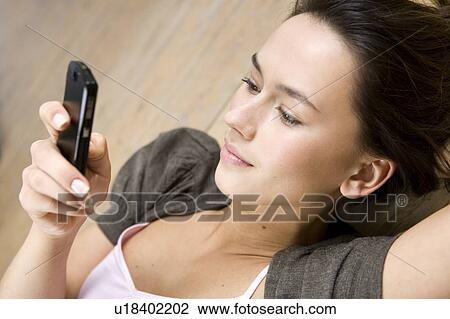 Stock Image - A young woman using a mobile phone. Fotosearch