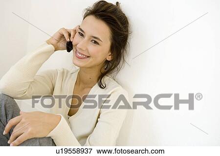 Stock Photo - A young woman using a mobile phone. Fotosearch