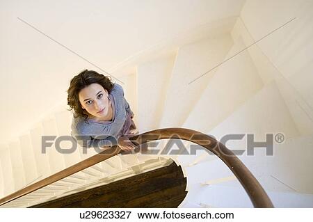 Stock Photo - A young woman walking up stairs. Fotosearch