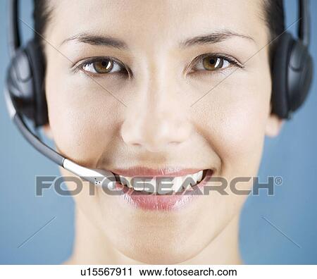 Stock Image - A young woman wearing an audio headset. Fotosearch