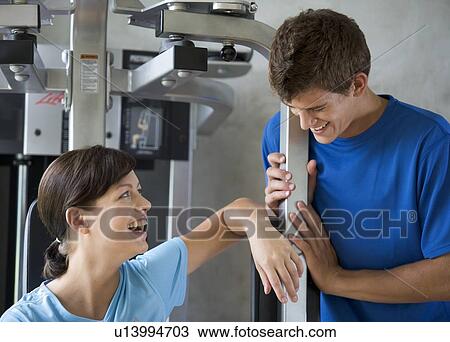 Stock Image - A young woman with a personal trainer. Fotosearch