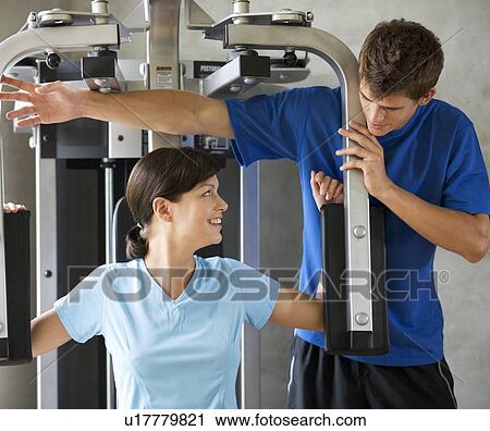 Stock Image - A young woman with a personal trainer. Fotosearch