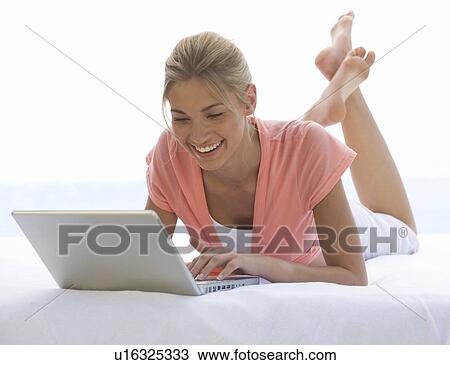 Stock Image - A young woman working on a laptop. Fotosearch