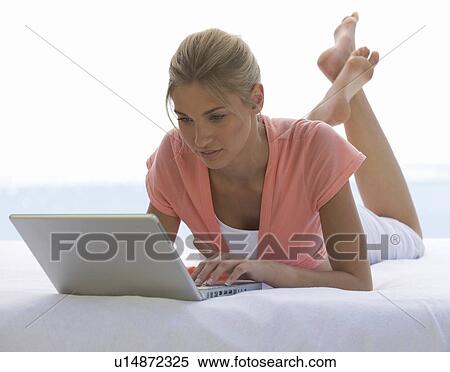 Stock Photography - A young woman working on a laptop. Fotosearch