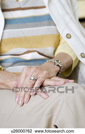 Stock Image - An elderly woman sitting in a chair. Fotosearch