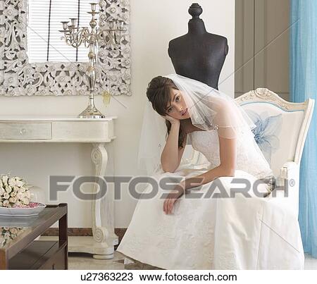 Stock Image - An unhappy bride sitting on a chair. Fotosearch