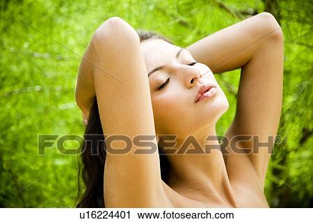 Beauty portrait of a woman in a tropical setting, hands behind her head. View Large Photo Image Stock Image - Beauty portrait of a woman in a tropical setting, hands behind her head.. Fotosearch