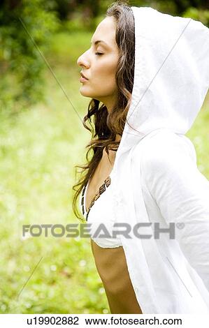 Stock Image - Beauty portrait of a woman strolling in a tropical setting.. Fotosearch