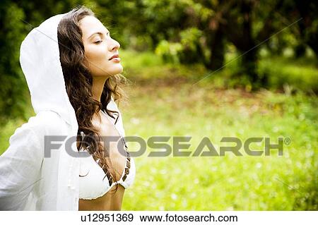 Stock Photo - Beauty portrait of a woman strolling in a tropical setting.. Fotosearch