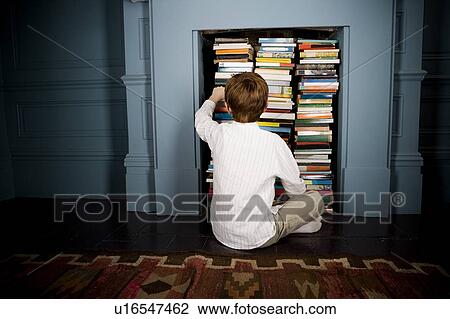 boy choosing book from bookshelf View Large Photo Image Stock Image - boy choosing book from bookshelf. Fotosearch
