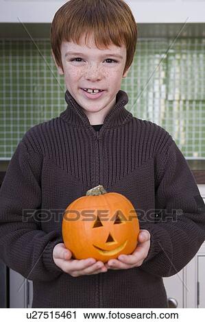 Stock Image - Boy holding a Jack'o Lantern for Halloween . Fotosearch